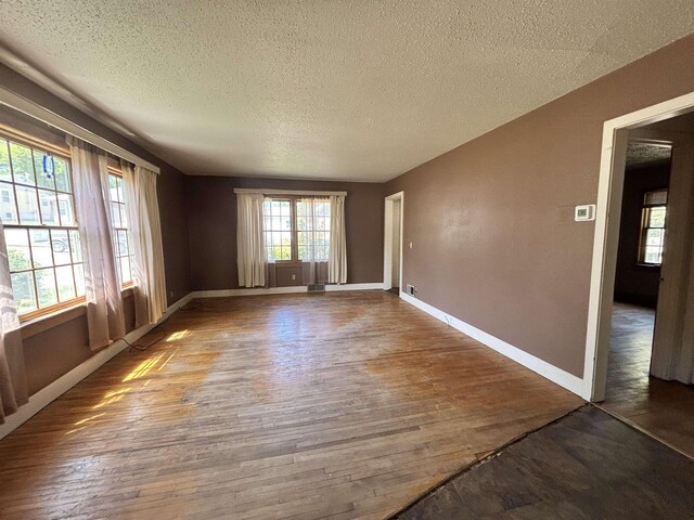 1107 SE 2nd St, Minot, ND 58701 - unfurnished room with wood finished floors, a textured ceiling, and baseboards