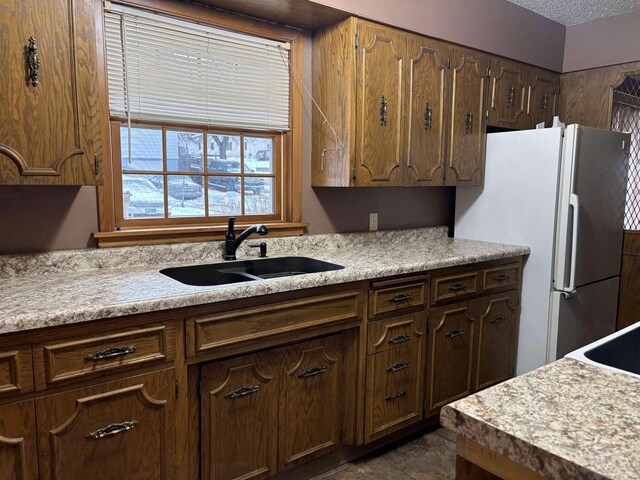 1107 SE 2nd St, Minot, ND 58701 - kitchen with a sink, freestanding refrigerator, and light countertops