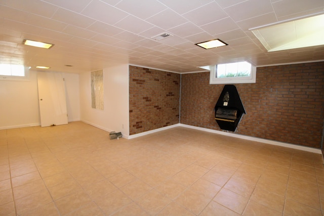 820 SW 5th St, Minot, ND 58701 - basement with baseboards, a wood stove, and brick wall
