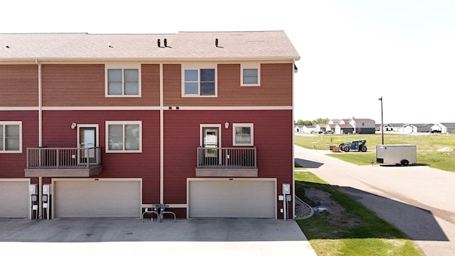 2947 8th St, Minot, ND 58703 - back of house with an attached garage, driveway, and a residential view