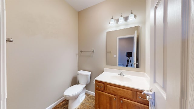 2947 8th St, Minot, ND 58703 - half bath with vanity, toilet, baseboards, and tile patterned flooring