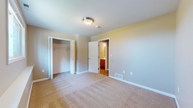 2947 8th St, Minot, ND 58703 - unfurnished bedroom featuring light colored carpet, baseboards, and a closet