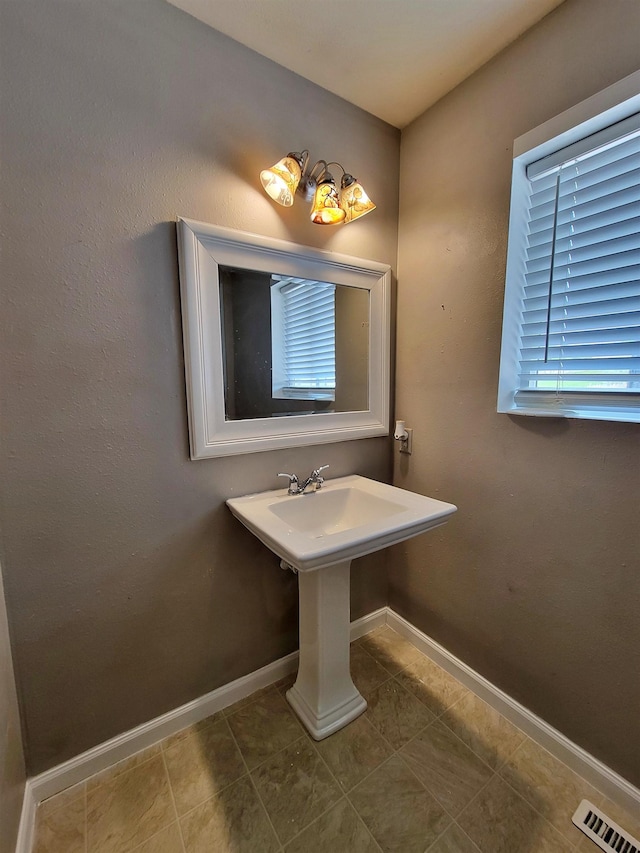 4920 10th Ave NW, Minot, ND 58703 - bathroom featuring baseboards and tile patterned flooring
