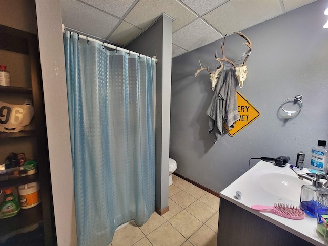 4920 10th Ave NW, Minot, ND 58703 - full bath with tile patterned floors, toilet, vanity, a drop ceiling, and curtained shower