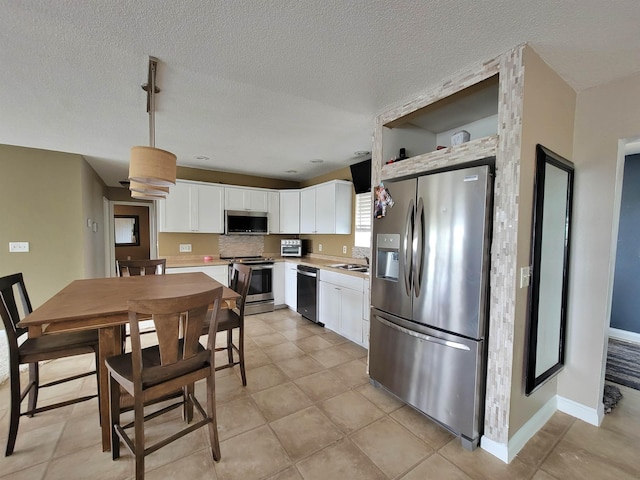 4920 10th Ave NW, Minot, ND 58703 - kitchen featuring stainless steel appliances, a sink, white cabinetry, light countertops, and open shelves