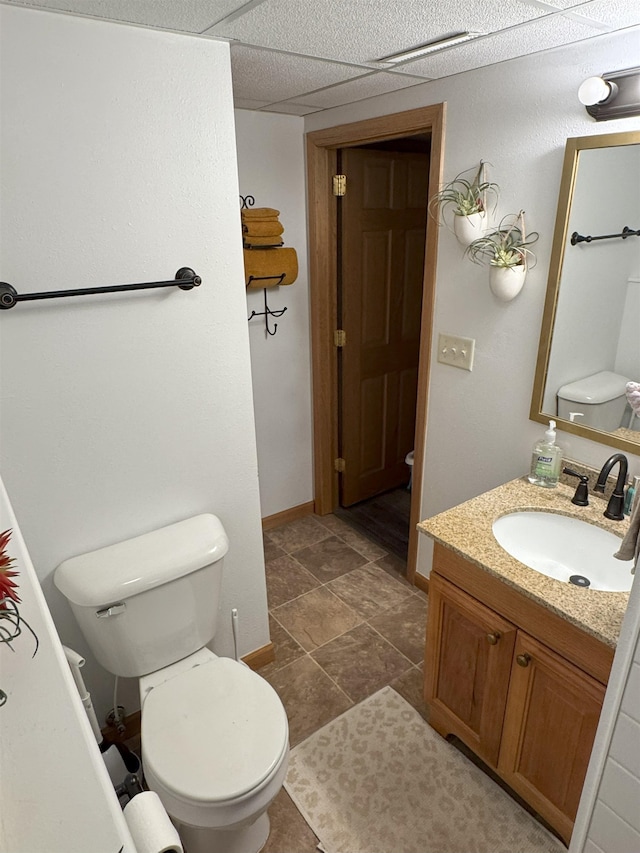 919 9th St, Minot, ND 58703 - bathroom with vanity, toilet, and baseboards
