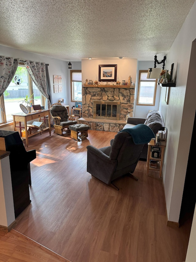 919 9th St, Minot, ND 58703 - living area with wood finished floors, a textured ceiling, and a stone fireplace