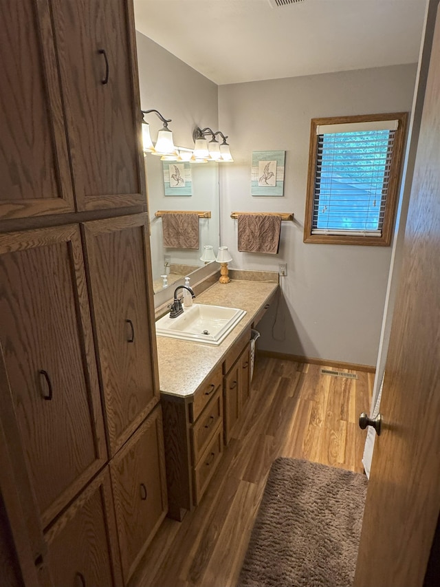 919 9th St, Minot, ND 58703 - bathroom with wood finished floors, vanity, and baseboards