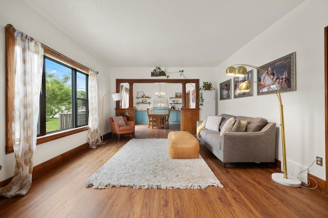 901 3rd St, Minot, ND 58701 - living area featuring wood finished floors, baseboards, and a chandelier