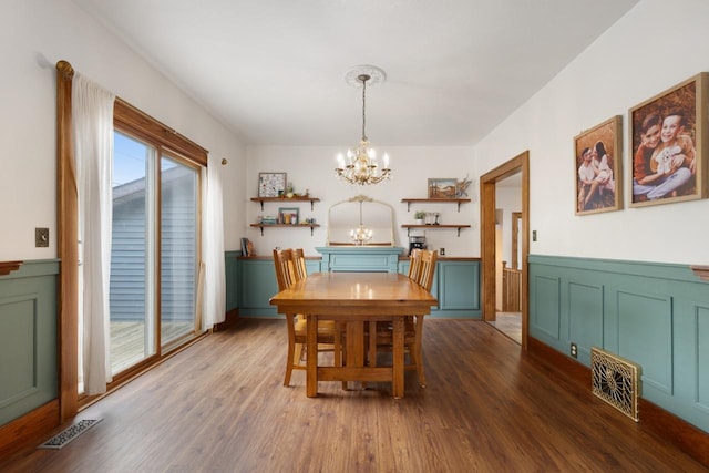 901 3rd St, Minot, ND 58701 - dining space featuring a chandelier, wood finished floors, and a wainscoted wall
