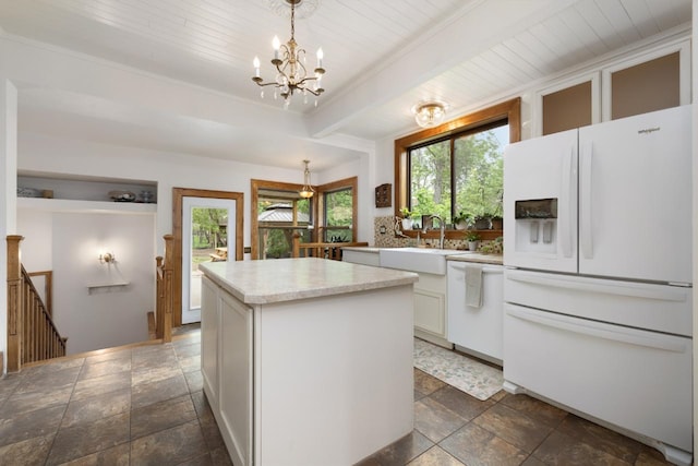 901 3rd St, Minot, ND 58701 - kitchen featuring white appliances, a sink, stone tile floors, a chandelier, and light countertops