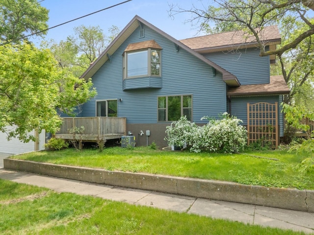 901 3rd St, Minot, ND 58701 - back of property featuring a wooden deck, central air condition unit, a yard, and roof with shingles