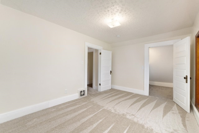 901 3rd St, Minot, ND 58701 - unfurnished bedroom with a textured ceiling, light carpet, and baseboards