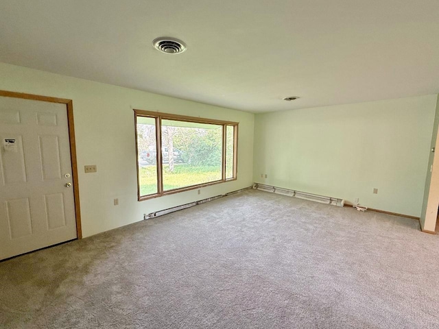 30 1st St, Sawyer, ND 58781 - carpeted empty room featuring a baseboard heating unit