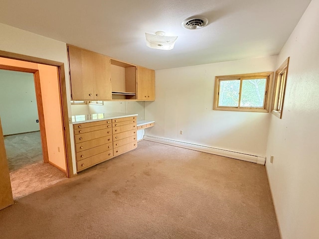30 1st St, Sawyer, ND 58781 - kitchen featuring a baseboard heating unit, light colored carpet, light countertops, and baseboards