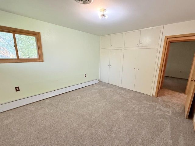 30 1st St, Sawyer, ND 58781 - unfurnished bedroom with baseboard heating, light carpet, and a closet