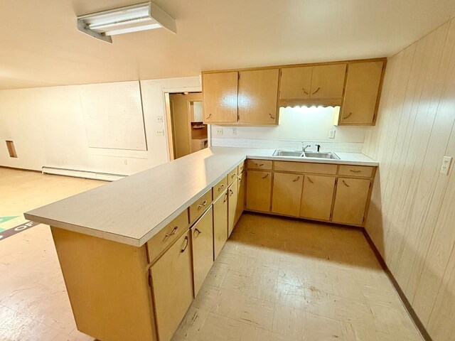 30 1st St, Sawyer, ND 58781 - kitchen featuring a sink, a baseboard radiator, light countertops, light floors, and a peninsula