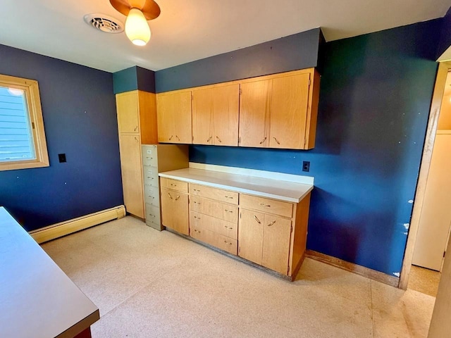 30 1st St, Sawyer, ND 58781 - kitchen with baseboard heating, light countertops, baseboards, and light brown cabinets
