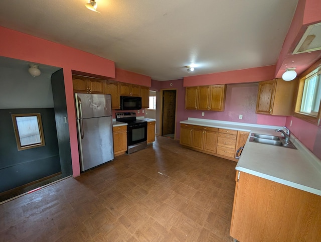 2704 SE 9th Ave, Minot, ND 58701 - kitchen featuring stainless steel appliances, a sink, light countertops, and brown cabinets