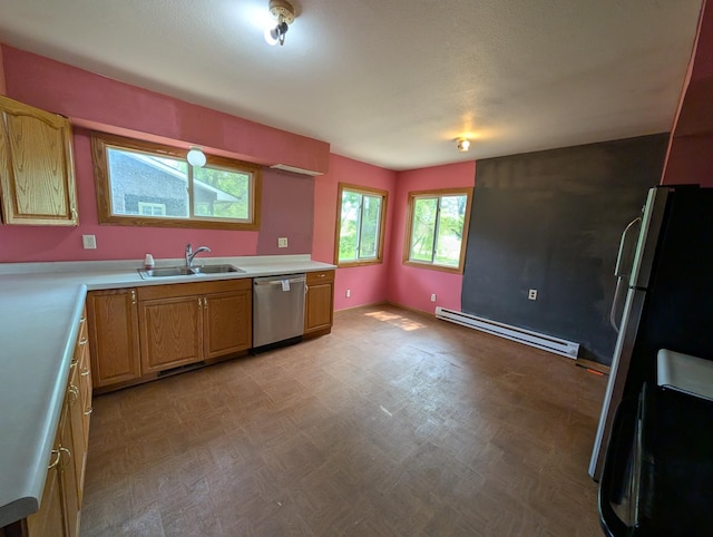 2704 SE 9th Ave, Minot, ND 58701 - kitchen with stainless steel appliances, baseboard heating, a sink, light countertops, and light floors