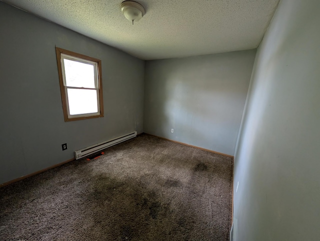 2704 SE 9th Ave, Minot, ND 58701 - spare room featuring a baseboard heating unit, carpet flooring, a textured ceiling, and baseboards