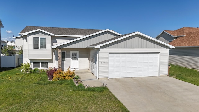 3421 8th St, Minot, ND 58703 - tri-level home with an attached garage, concrete driveway, a front yard, and a shingled roof