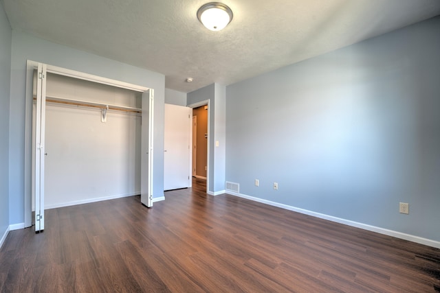 3421 8th St, Minot, ND 58703 - unfurnished bedroom featuring dark wood-style flooring, baseboards, and a closet