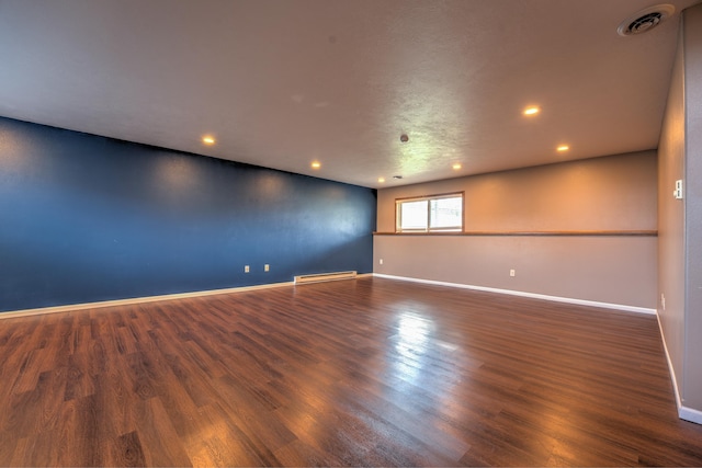3421 8th St, Minot, ND 58703 - unfurnished room featuring a baseboard heating unit, baseboards, wood finished floors, and recessed lighting
