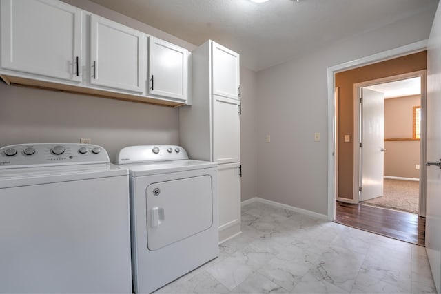3421 8th St, Minot, ND 58703 - laundry room featuring light marble finish floors, cabinet space, separate washer and dryer, and baseboards