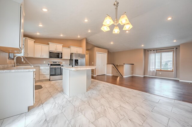 3421 8th St, Minot, ND 58703 - kitchen featuring stainless steel appliances, open floor plan, a sink, a center island, and light countertops