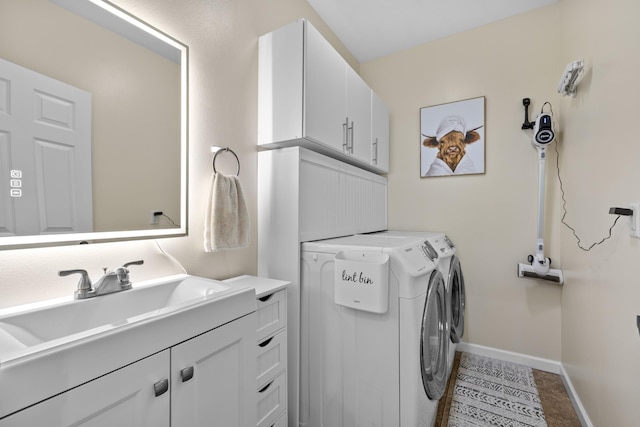 1321 Golden Valley Ln, Minot, ND 58703 - washroom featuring baseboards, cabinet space, washer and clothes dryer, and tile patterned flooring