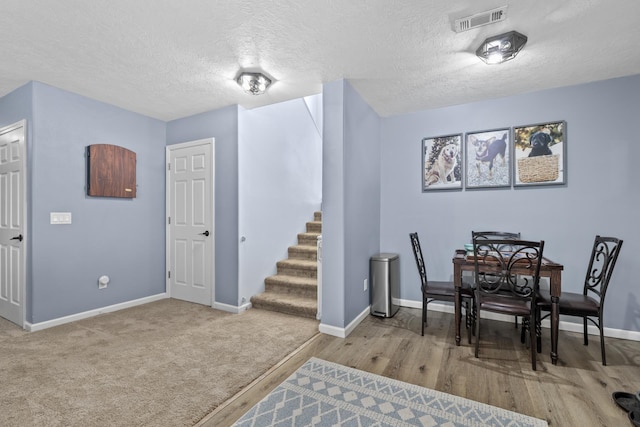 1321 Golden Valley Ln, Minot, ND 58703 - dining room featuring baseboards, stairway, a textured ceiling, and wood finished floors