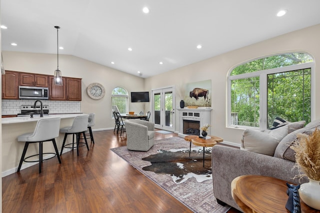 1321 Golden Valley Ln, Minot, ND 58703 - living room with dark wood-style floors, lofted ceiling, a fireplace, recessed lighting, and baseboards