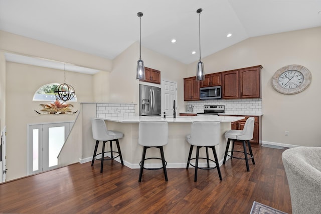 1321 Golden Valley Ln, Minot, ND 58703 - kitchen featuring appliances with stainless steel finishes, a peninsula, a breakfast bar area, decorative backsplash, and recessed lighting