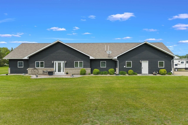 6125 11th Ave, Minot, ND 58701 - back of house with a lawn, roof with shingles, and a patio area