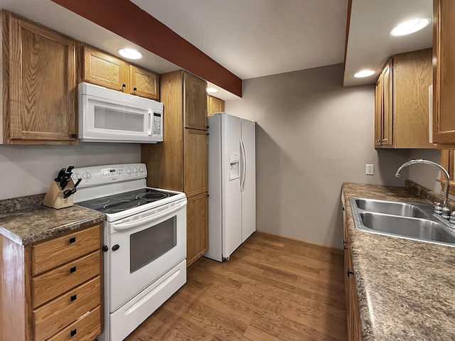 424 26th St, Minot, ND 58703 - kitchen with white appliances, a sink, brown cabinetry, recessed lighting, and light wood-style flooring