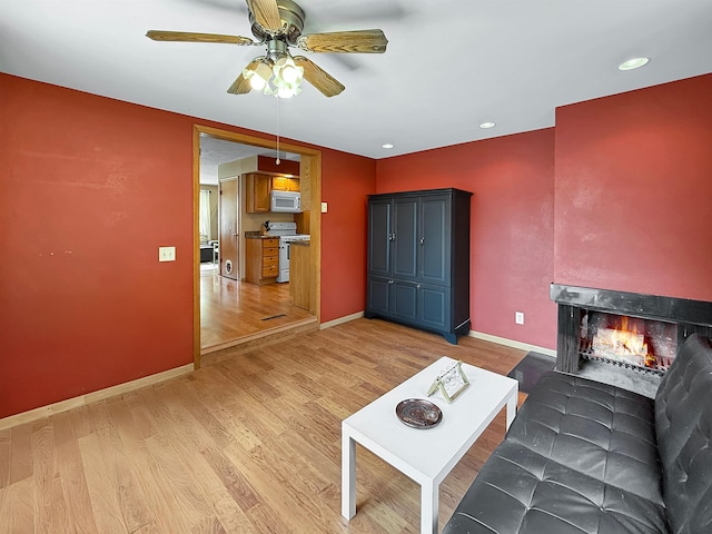 424 26th St, Minot, ND 58703 - living room featuring ceiling fan, light wood-style flooring, baseboards, a multi sided fireplace, and recessed lighting