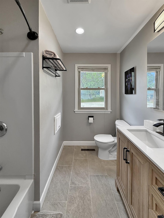 424 26th St, Minot, ND 58703 - full bathroom featuring vanity, toilet, healthy amount of natural light, and baseboards