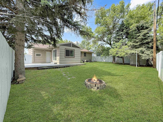 424 26th St, Minot, ND 58703 - view of yard with a fire pit and a wooden deck