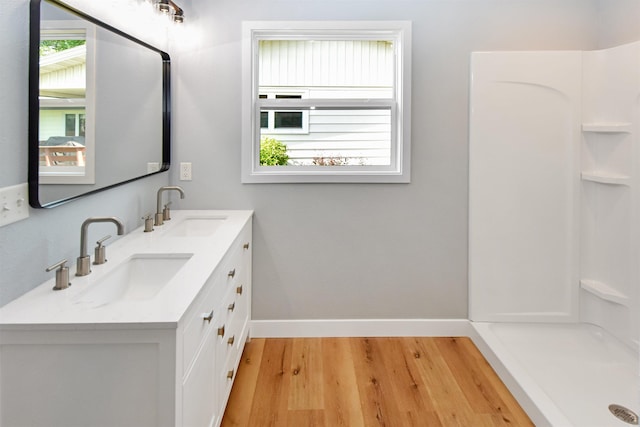 1821 11th St, Minot, ND 58701 - full bath with baseboards, double vanity, and wood finished floors
