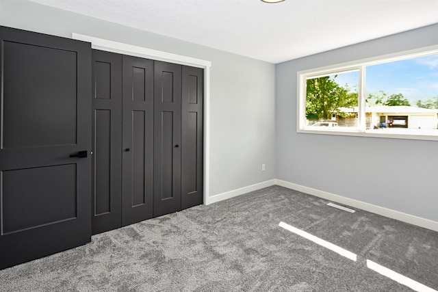 1821 11th St, Minot, ND 58701 - unfurnished bedroom with a closet, baseboards, and carpet flooring