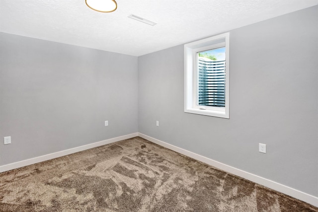 1821 11th St, Minot, ND 58701 - spare room with carpet floors, baseboards, and a textured ceiling
