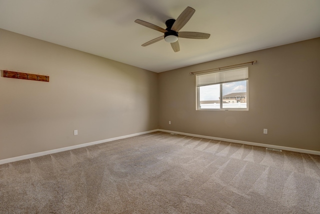 3328 NW 20th Ave, Minot, ND 58703 - empty room featuring a ceiling fan, baseboards, and light carpet