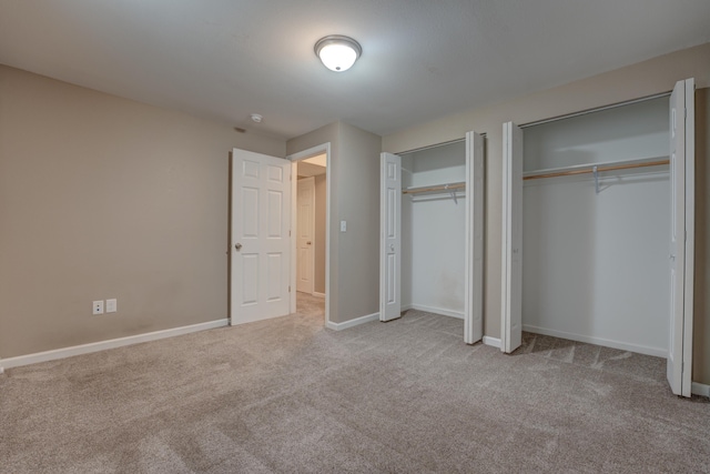 3328 NW 20th Ave, Minot, ND 58703 - unfurnished bedroom with two closets, carpet flooring, and baseboards