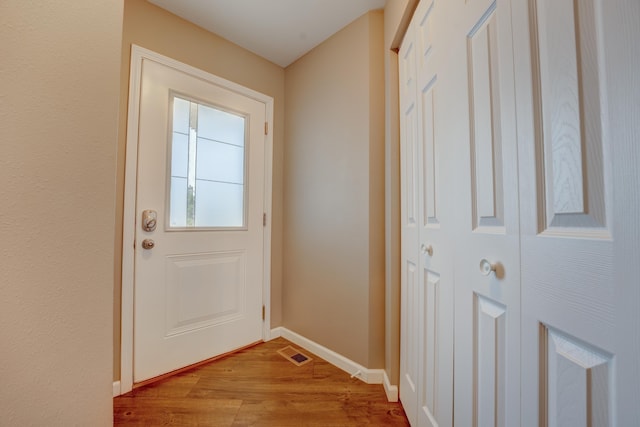 3328 NW 20th Ave, Minot, ND 58703 - doorway to outside featuring wood finished floors and baseboards