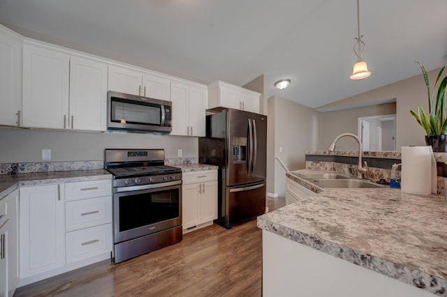 3328 NW 20th Ave, Minot, ND 58703 - kitchen with stainless steel appliances, a sink, dark wood-type flooring, white cabinetry, and hanging light fixtures