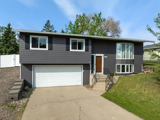 1925 10th St, Minot, ND 58703 - bi-level home featuring an attached garage and concrete driveway