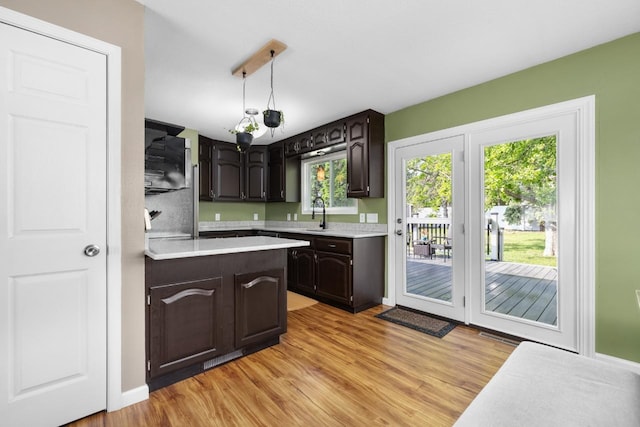 1925 10th St, Minot, ND 58703 - kitchen featuring light countertops, light wood finished floors, and dark brown cabinets