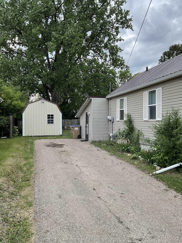 525 12th St, Minot, ND 58703 - view of side of home featuring asphalt driveway and metal roof