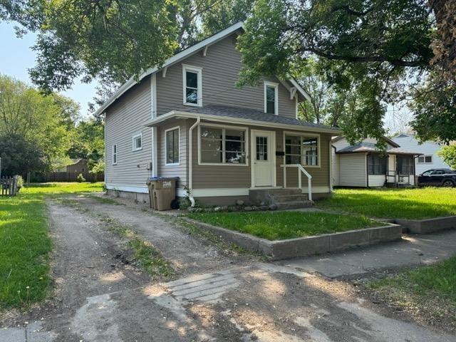 616 10th St, Minot, ND 58703 - view of front facade featuring a front yard and asphalt driveway
